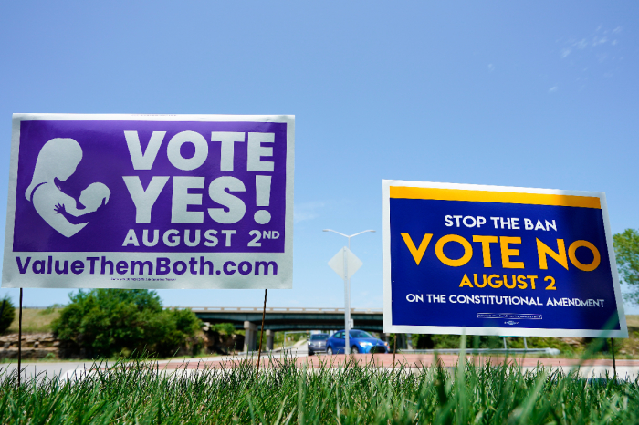 Signs in favor and against the Kansas constitutional amendment on abortion are displayed outside Kansas 10 highway on Aug. 1, 2022, in Lenexa, Kansas. 