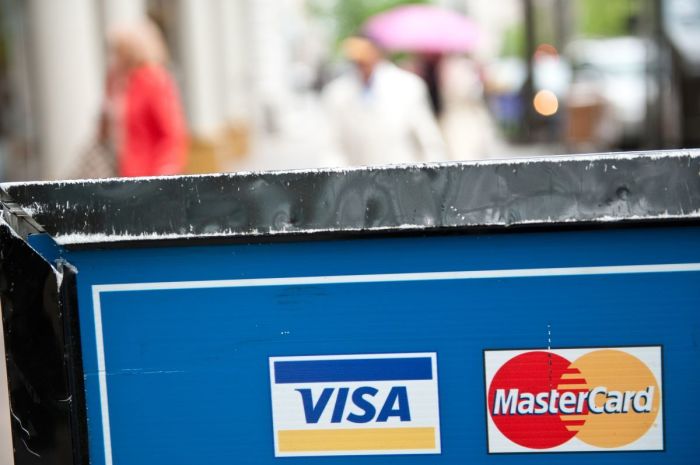 Visa and MasterCard credit card logos are seen on a sign in Washington on March 30, 2012. NICHOLAS KAMM/AFP via Getty Images) 