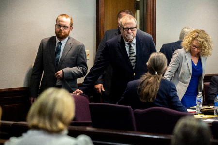 Greg McMichael, center, and his son, Travis McMichael, left, look at family members seated in the gallery when they walk into the courtroom for the reading of the jury's verdict of Greg McMichael and his son, Travis McMichael, and a neighbor, William 