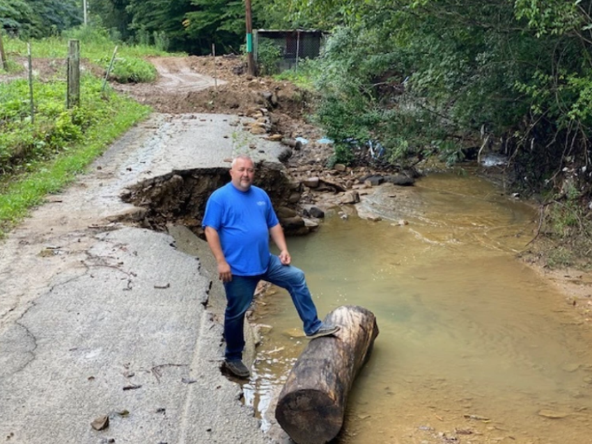 Pastor Brad Stevens of the Church of God Worship Center in Clay County stands near a damaged road in East, Kentucky, which was hit by flash flooding after record rain fell for four consecutive days at the end of July 2022. 