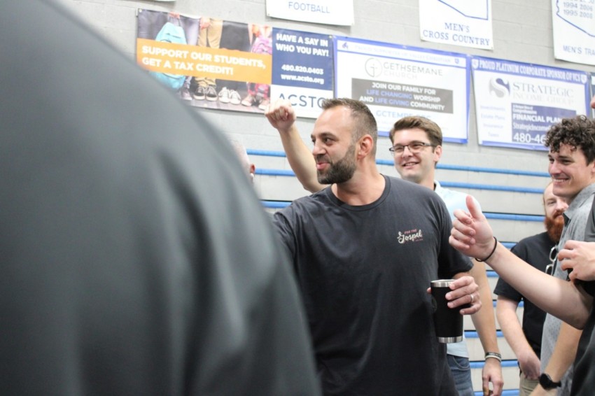 Shepherd's House Bible Church teaching pastor Costi Hinn (middle) gives a pre-service motivational message to church volunteers in July 2022.