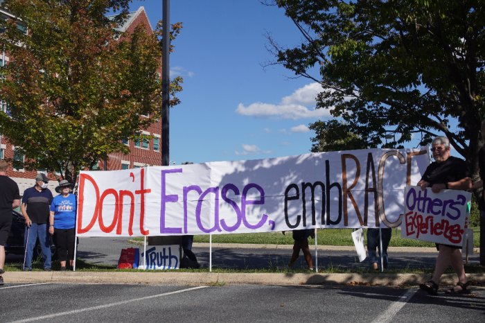 Counterprotesters hold signs during a rally outside the Loudoun County Public Schools headquarters in Broadlands, Virginia, on Sept. 13, 2022.