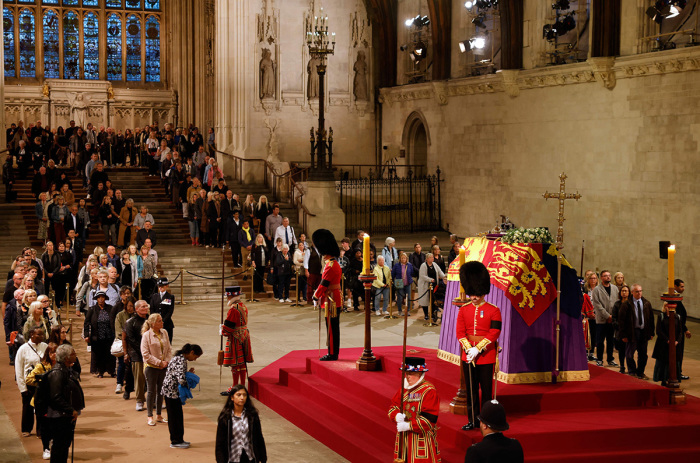 Members of the public pay their respects as they pass the coffin of Queen Elizabeth II as it Lies in State inside Westminster Hall, at the Palace of Westminster in London on September 15, 2022. - Queen Elizabeth II will lie in state in Westminster Hall inside the Palace of Westminster, until 0530 GMT on September 19, a few hours before her funeral, with huge queues expected to file past her coffin to pay their respects. 