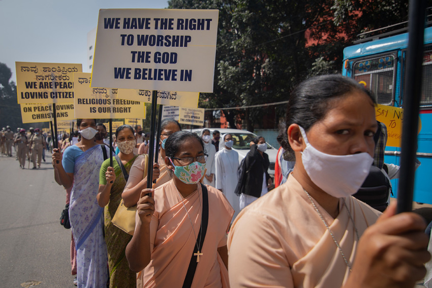 Christian nuns wave placards as they march during a demonstration against the tabling of the Protection of Right to Freedom of Religion Bill on December 22, 2021, in Bengaluru, India. The Protection of Right to Freedom of Religion Bill also known as the Anti-Conversion Bill makes provisions for the prohibition of unlawful conversion from one religion to another by force, allurement or by any fraudulent means with punishments ranging between a minimum of three years and a maximum of 10 years along with monetary penalties. However, leaders of opposition political parties and activists allege that this law targets Muslims and interfaith couples and is a tool provided to pro-Hindu activists to harass interfaith couples from entering into consenting relationships and marriages.