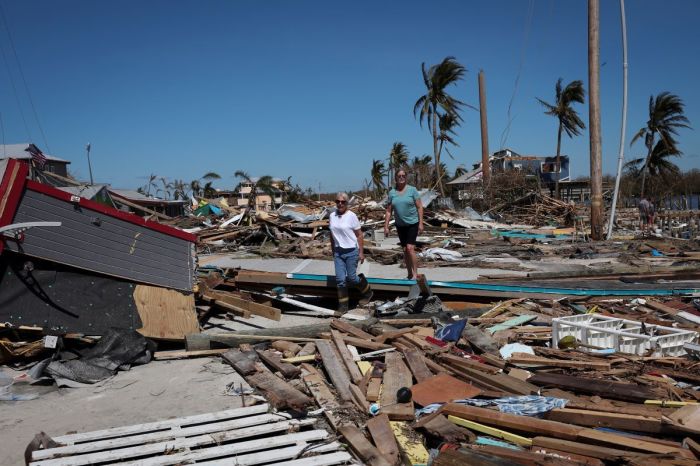 Residents of Pine Island walk amongst the wreckage left in the wake of Hurricane Ian on the island of Matlacha on Sept. 30, 2022, in Matlacha, Florida.