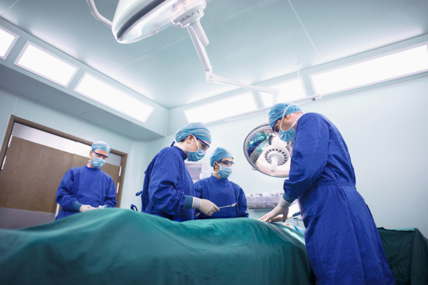 Operating room staff performs a surgery.