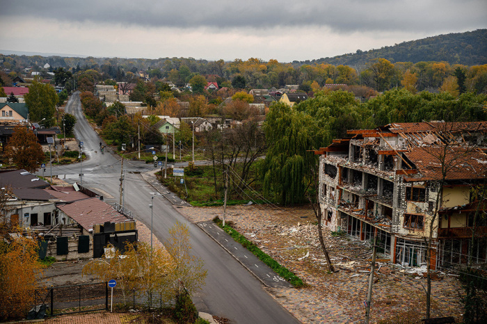 Local residents ride bicycles as damaged buildings are seen in Svyatohirs'k, Donetsk region, on Oct. 20, 2022, after the liberation of the area. 