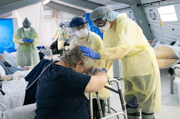 A patient receives care from doctors and nurses at the Samaritan's Purse emergency field hospital in Cremona, Italy, during the COVID-19 pandemic in 2020. 