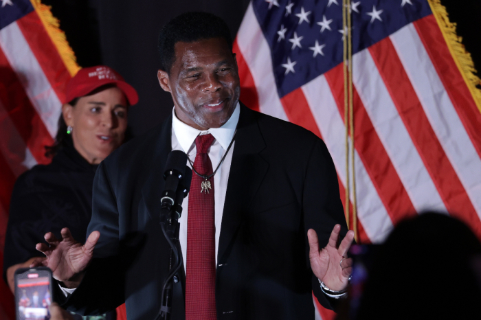 Republican U.S. Senate candidate Herschel Walker speaks to supporters as his wife, Julie Blanchard, looks on during an election night event on Nov. 8, 2022, in Atlanta, Georgia. 