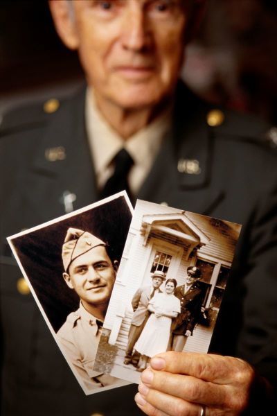World War II veteran holding photographs.