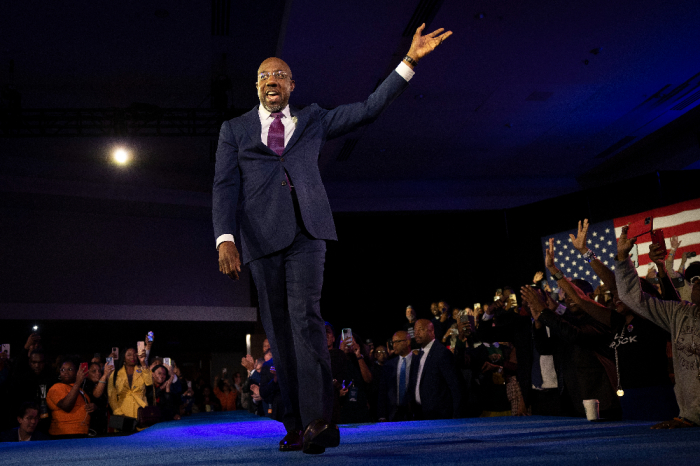 Georgia Dem Senate candidate U.S. Sen. Raphael Warnock, D-Ga., waves to supporters as he walks on stage to speak during an election night watch party at the Marriott Marquis on Dec. 6, 2022, in Atlanta, Georgia.