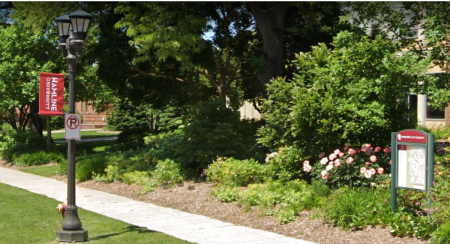 A banner advertising Hamline University appears on a lamp post located on the school’s campus in St. Paul, Minnesota, located near one of several campus maps displayed throughout the school grounds.