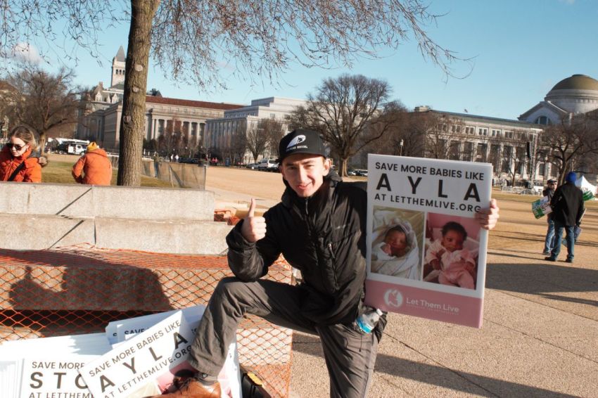 Maison Des Champs, a pro-life activist who calls himself the "Pro-Life Spiderman," poses with signs at the March for Life in Washington, D.C., on Jan. 20, 2023.