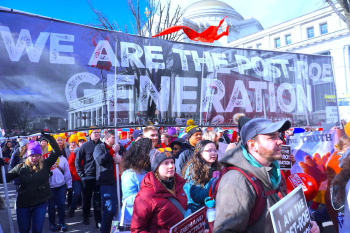 Demonstrators hold a banner expressing their opposition to abortion as they walk in the streets of Washington, D.C., on Jan. 20, 2023, for the March for Life. 