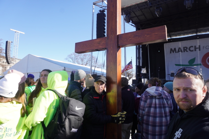 Dan Beazley from Northville, Michigan, holds a 65-pound cross to show his solidarity and support for the anti-abortion March for life on Jan. 20, 2023, in Washington, D.C.