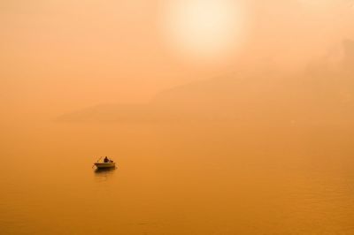 A fisherman at the end of the day in the yellow sunset light. The picture was shooted on lake Como.
