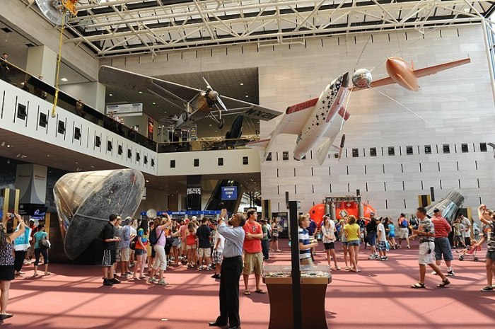 Patrons visit the entrance hall of the National Air and Space Museum in Washington, D.C. Among the visible aircraft were Spirit of The St. Louis, the Apollo 11 command module, Space Ship One and X-1. https://commons.wikimedia.org/wiki/File:National_Air_and_Space_Museum_Entrance.JPG