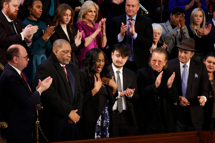 Rodney Wells (2nd L) and RowVaughn Wells, step-father and mother of police murder victim Tyre Nichols, are applauded by Brandon Tsay (C), hero of the Monterey, California, shooting; Irish singer-songwriter Bono; Paul Pelosi; first lady Jill Biden; second gentleman Doug Emhoff and others during U.S. President Joe Biden's State of the Union address in the House Chambers of the U.S. Capitol on Feb. 7, 2023, in Washington, DC. 