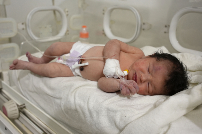 A newborn baby who was found still tied by her umbilical cord to her mother and pulled alive from the rubble of a home in northern Syria following a deadly earthquake receives medical care at a clinic in Afrin on February 7, 2023. 