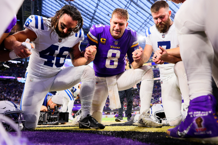 Kirk Cousins #8 of the Minnesota Vikings prays with Indianapolis Colts players after their game at U.S. Bank Stadium on December 17, 2022 in Minneapolis, Minnesota. 