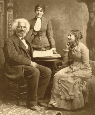 A family photo of Frederick Douglass and his second wife, Helen Pitts Douglass. Standing in the background is Helen's sister, Eva Pitts. 