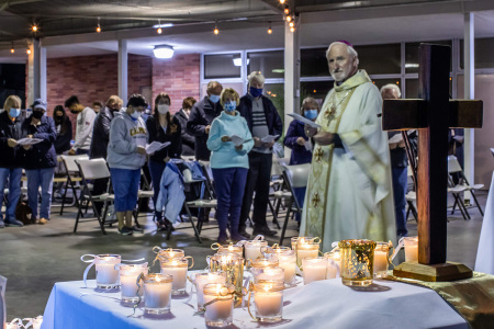 Bishop David O'Connell looks at candles placed on an altar representing people who lost their lives during the coronavirus pandemic, during a non-denominational memorial service to provide a space for community members who have lost loved ones in 2020 at the Saint Cornelius Catholic Church in Long Beach, California on November 14, 2020.