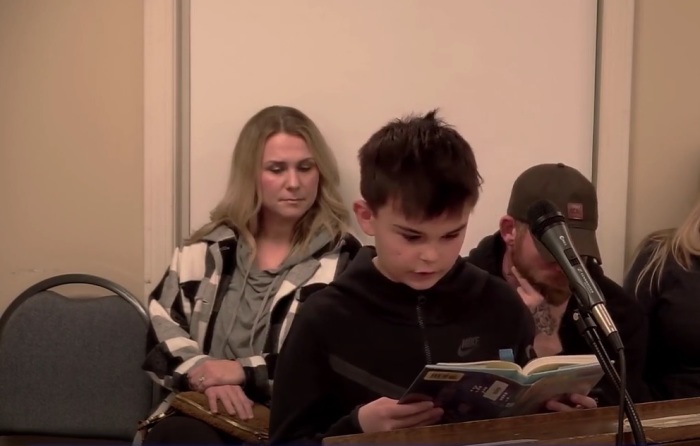 Knox Zajac, an 11-year-old middle school student, reads from a sexually explicit book that was available at his public school library before a school board meeting in Windham, Maine, on Feb. 15, 2023. 