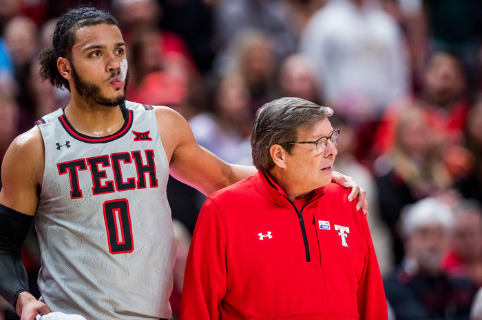 Forward Kevin Obanor No. 0 of the Texas Tech Red Raiders puts his arm around head coach Mark Adams during the first half of the college basketball game against the West Virginia Mountaineers at United Supermarkets Arena on January 25, 2023, in Lubbock, Texas. 