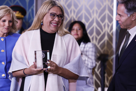 Alba Rueda, a man from Argentina, is presented with an award by first lady Jill Biden and U.S. Secretary of State Antony J. Blinken at the 17th annual International Women of Courage Award Ceremony in the East Room of the White House on March 08, 2023 in Washington, DC.