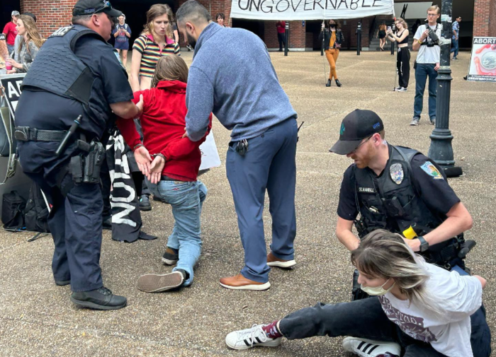 Pro-abortion students Ian Dinkla (left) and Bryn Taylor (right) are arrested following a scuffle that ensued when a plainclothes detective confronted Dinkla for stealing the pro-life group Created Equal's anti-abortion display. 