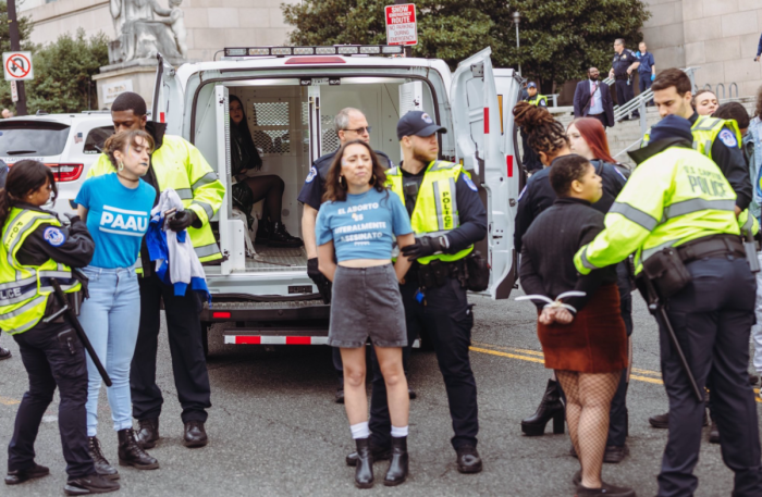 Pro-life activists affiliated with the Progressive Anti-Abortion Uprising are arrested as they protest on Capitol Hill, Mar. 23, 2023. From left to right: PAAU Digital Content Creator Elise Ketch, Melanie Salazar, PAAU organizer Melanie Salazar and Constance Becker. PAAU Founder and Executive Director Terrisa Bukovinac is pictured seated in the police van. 