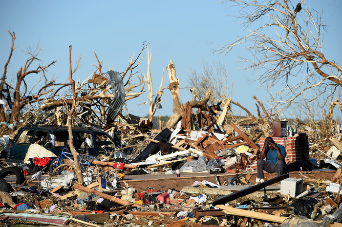 A man sits amongst damage from a series of powerful storms and at least one tornado on March 25, 2023, in Rolling Fork, Mississippi. At least 26 people have reportedly been killed with dozens more injured following devastating storms across western Mississippi and Alabama on Friday night. 
