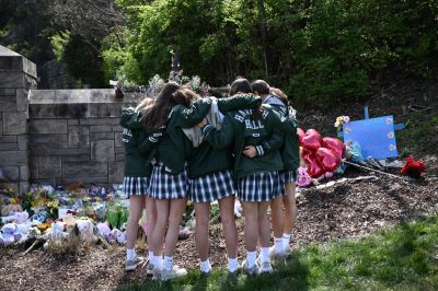 Girls embrace in front of a makeshift memorial for victims by the Covenant School building at the Covenant Presbyterian Church following a shooting, in Nashville, Tennessee, March 28, 2023. A heavily armed former student killed three young children and three staff in what appeared to be a carefully planned attack at a private elementary school in Nashville on Monday, before being shot dead by police. Chief of Police John Drake named the suspect as Audrey Hale, 28, who the officer later said identified as transgender. 