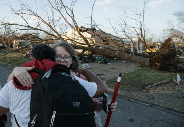 A residents embrace while evacuating their neighborhood after a large tornado damaged hundreds of homes and buildings on March 31, 2023, in Little Rock, Arkansas. Tornados damaged hundreds of homes and buildings Friday afternoon across a large part of Central Arkansas. Governor Sarah Huckabee Sanders declared a state of emergency after the catastrophic storms that hit on Friday afternoon. According to local reports, the storms killed at least three people. 