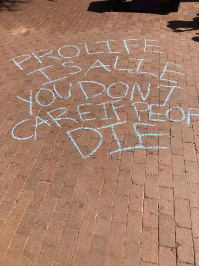 Students at Georgetown University chalk pro-choice messages during a Students for Life of America tabling event on Thursday, April 20, 2023.