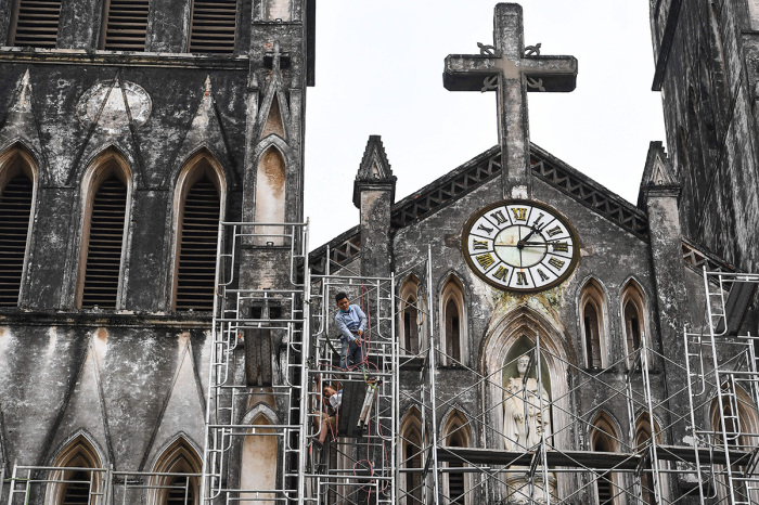 Workers erect scaffolding to aid the renovation of the Saint Joseph Cathedral in Hanoi on April 27, 2021. 