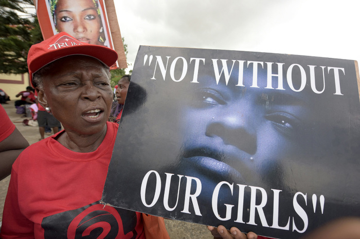 A member of 'Bring Back Our Girls' movement carries placard to press for the release of the missing Chibok schoolgirls in Lagos, on April 14, 2016. - Nigeria's government said it was studying a 'proof of life' video showing 15 of the more than 200 schoolgirls abducted by Boko Haram, as parents and their supporters marked the second anniversary of the kidnapping. A total of 276 girls were abducted from the Government Girls Secondary School in Chibok, northeast Nigeria, on April 14, 2014,. Fifty-seven escaped in the immediate aftermath. 