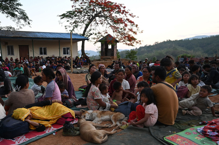 People wait at a temporary shelter in a military camp, after being evacuated by the Indian army, as they flee ethnic violence that has hit the northeastern Indian state of Manipur on May 7, 2023. Some 23,000 people have fled ethnic violence in northeast India that has reportedly killed at least 54, the army said on May 7, 2023, although there was no new 'major violence' overnight. 