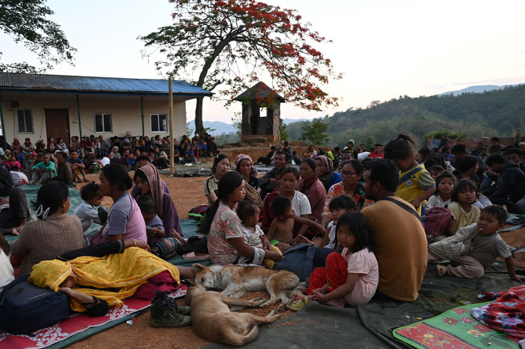 People wait at a temporary shelter in a military camp, after being evacuated by the Indian army, as they flee ethnic violence that has hit the northeastern Indian state of Manipur on May 7, 2023. Some 23,000 people have fled ethnic violence in northeast India that has reportedly killed at least 54, the army said on May 7, 2023, although there was no new 