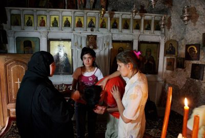 A nun blesses a boy as he visits with his family the Christian Orthodox monastery of Saint Taqla in the Syrian village of Maalula, 60 kms north of Damascus, on June 29, 2009. Maalula is one of the last corners in the world where its residents still speak Aramaic, the mother tongue of Jesus Christ. 