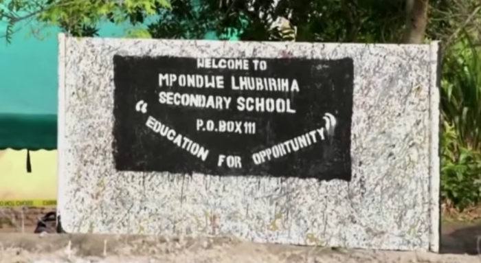 A sign sits outside the Lhubiriha Secondary School in Mpondwe town in western Uganda near the border of the Democratic Republic of Congo.