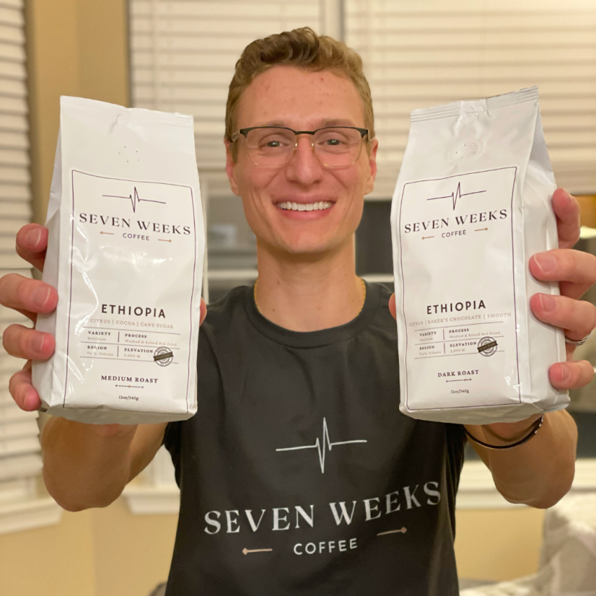 Seven Weeks Coffee Founder Anton Krecic holds up packages of coffee.