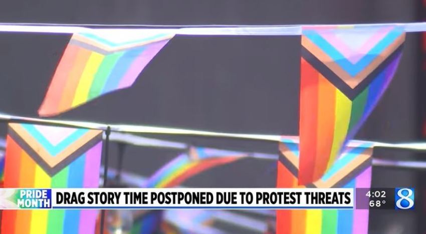 A screenshot of a lower third on-air graphic from NBC affiliate WOOD-TV describing the cancellation of a pride event due to "protest threats."
