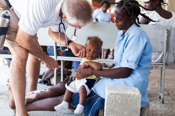 LiveBeyond co-founder Dr. David Vanderpool examines a baby at their compound in Haiti.