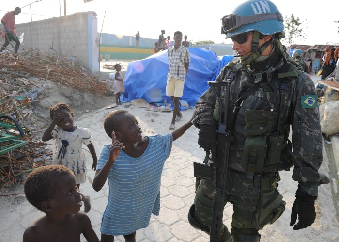 A Brazilian U.N. peacekeeper walks with Haitian children during a patrol in Cite Soleil, a section of Port-au-Prince.