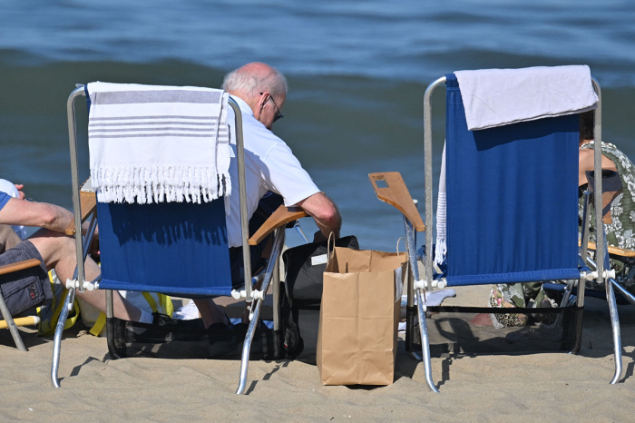 U.S. President Joe Biden sits with others on the beach in Rehoboth Beach, Delaware on August 13, 2023. 