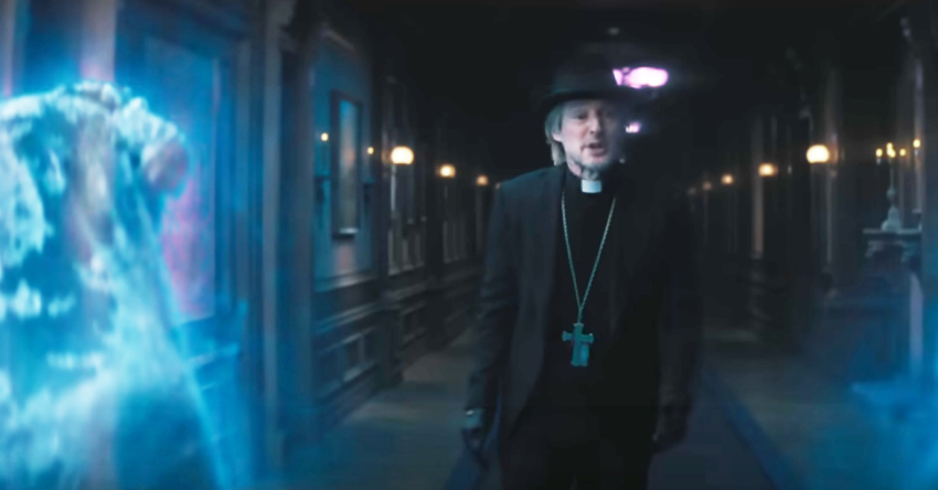 Father Kent (Owen Wilson) is confronted by two spirits in "Haunted Mansion."