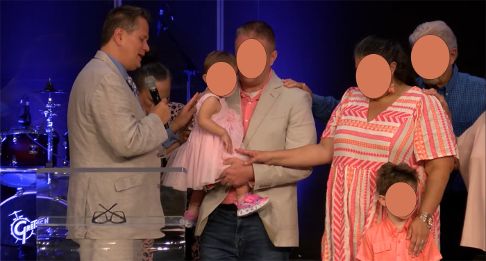 John Blanchard (L) who serves as senior pastor of The Rock Church of Virginia Beach, Virginia, with his wife, Robin, pray for a young girl during a dedication on Aug. 27, 2023.