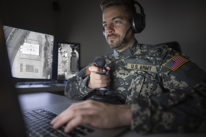 American soldier in headquarters control center initializing drone attack. Modern warfare.