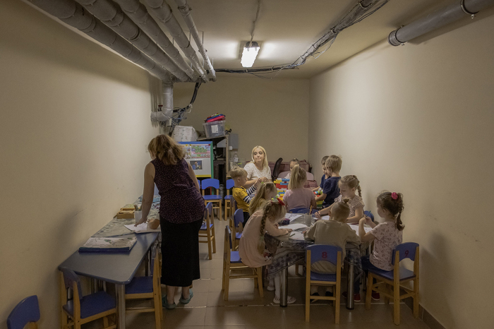 Children and their teachers wait in a kindergarten's basement used as a bomb shelter during an air strike alarm in Kryvyi Rih, southern Ukraine, on September 14, 2023, amid the Russian invasion of Ukraine. 
